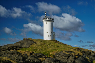 Fototapeta na wymiar Elie light house with blue sky and cloud formations, located in Fife, Scotland.
