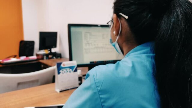 Chica joven trabajando frente a una laptop.  vista desde el hombro