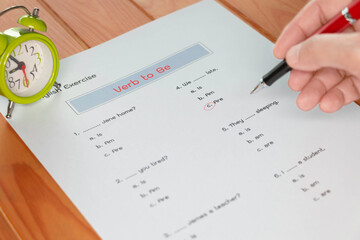 English grammar test sheet on wooden table