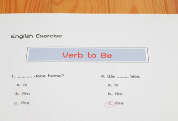 English grammar test sheet on wooden table