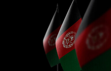 Small national flags of the Afghanistan on a black background