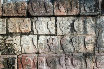 Skulls carved on stone wall in Ruins, texture