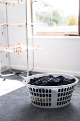 laundry basket with clean laundry to be hung on clothes airer next to it, household chores and daily life routine