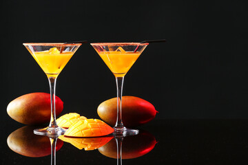 Glasses of tasty mango margarita on dark background