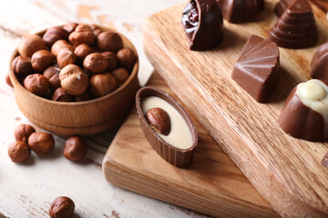 Tasty chocolate candies with hazelnuts on table