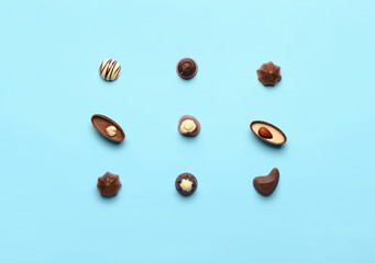 Tasty chocolate candies on color background