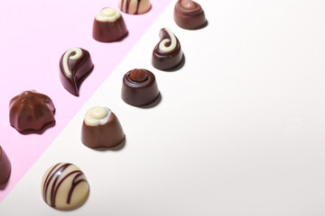 Tasty chocolate candies on color background