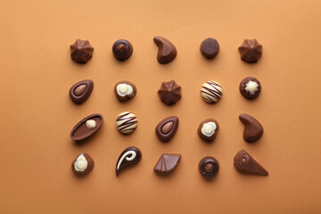 Tasty chocolate candies on color background