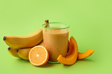 Glass of healthy smoothie and ingredients on color background