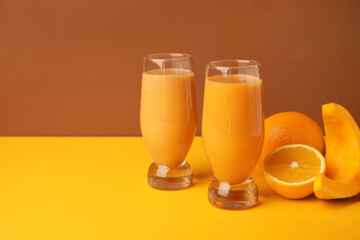 Glasses of healthy smoothie and ingredients on color background