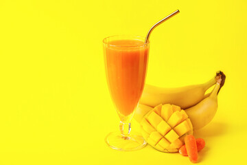 Glass of healthy smoothie and ingredients on color background