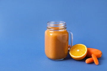 Mason jar of healthy smoothie and ingredients on color background