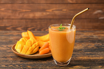 Glass of healthy smoothie and ingredients on wooden background