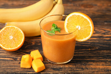 Glass of healthy smoothie and ingredients on wooden background
