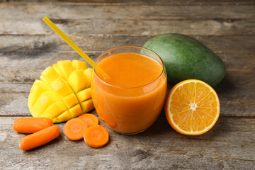 Glass of healthy smoothie and ingredients on wooden background