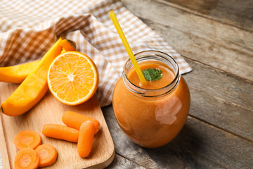 Jar of healthy smoothie and ingredients on wooden background