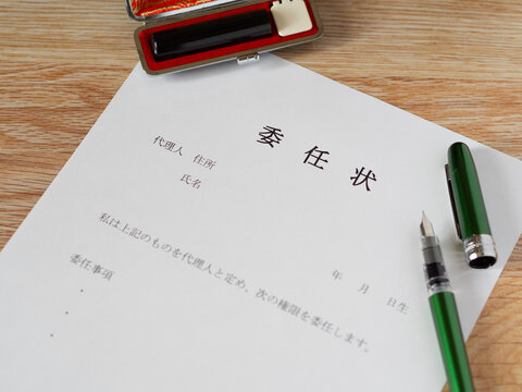 未記入の委任状と万年筆と印鑑