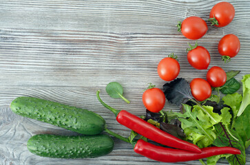 tomatoes, cucumbers, red chilli peppers and fresh greens on table. fresh vegetables on wooden background. copy space, top view