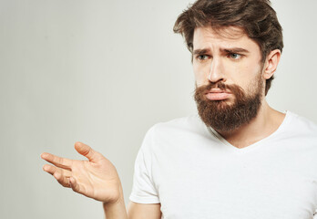 Sad guy with bushy beard gestures with his hands Copy Space cropped view