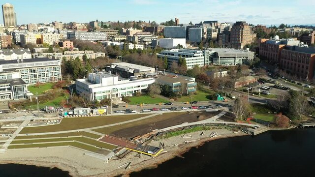 Cinematic aerial dolly drone footage of the Fritz Hedges Waterway Park, University of Washington with surrounding commercial and residential area, dormitories and classroom buildings in the background