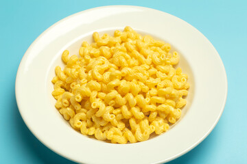 Pasta background. Mac and Cheese pasta on a blue background. American style Italian pasta with cheese.