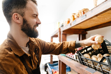 White bearded seller man smiling while working in local eco shop