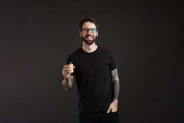 Bearded happy man smiling while drinking coffee takeaway