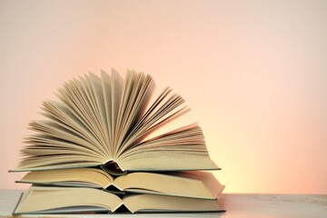 Reading books and literature.Open books stack set on a light pink  background. Study and education concept.  Close-up book pages.Learning and knowledge 	