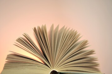 Reading books and literature.Open books  on a light pink  background. Study and education concept.  Close-up book pages.Learning and knowledge concept.	