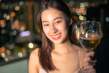 Young asian woman with sparklers is dancing and celebrating a new year. Fireworks, bengal lights in slow motion. Having fun at rooftop in the city.close up sparklers portrait low light.