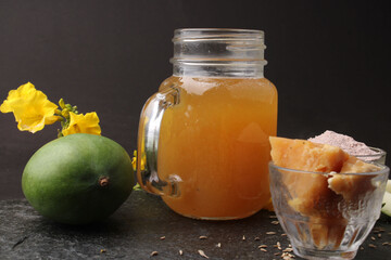 Raw Mango juice - Aam Panna or Panha in a transparent glass with whole green fruit,