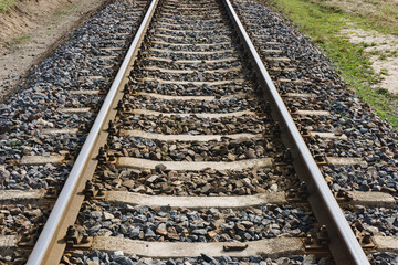 Fototapeta premium Railroad background. Railway perspective. Train track landscape. Old railroad wooden tie. Track ballast gravel made of crushed stone.
