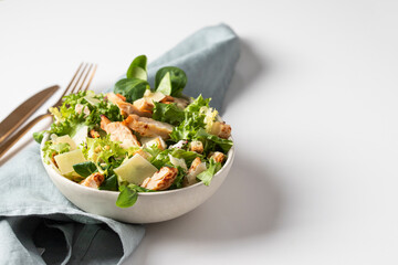 Homemade Caesar salad in the white plate on the white background. Fitness salad with  different...