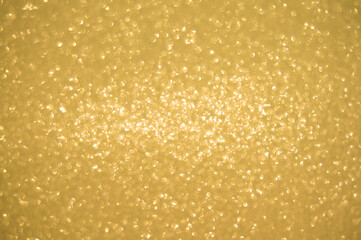 Gold glitters background. shimmering blur spot lights Bokeh Shiny gold light background.