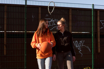 Two teenage girls are playing one on one basketball on a beautiful sunny day.