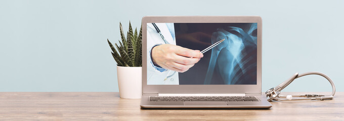 Stethoscope on a laptop. Virus season, pandemic. Remote medicine or elearning and telemedicine and consultation advice. Copy space. Medical network . Doctor hand with xray imaging on screen banner