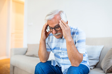 Attack of the monster migraine. Unhappy Retired Senior man holding his head with pain expression ....