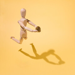 A wooden doll in her hand holds a quail egg floating above a yellow background