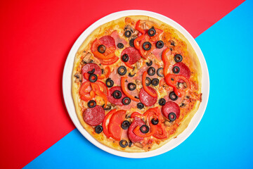 A whole, cooked and sliced peperoni pizza on a colorful backgroud, various colors. Copy space banner.