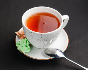 Tea cup with tea pot over black background. Tea time.