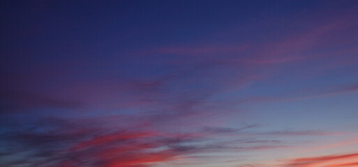 Obraz premium Colorful dramatic sky with clouds at sunset. City during warm sunset