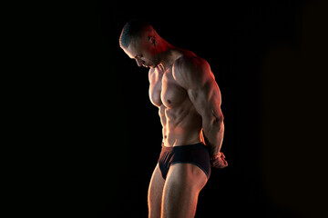 Active lifestyle concept. Professional bodybuilder showing perfect muscular body, lamps...