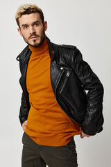 Obraz premium stylish blond man in a sweater and a leather jacket on a light background