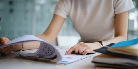 Young accountant woman analyzes financial data pointing at paperwork and summarize big data. business,tax, financial concept.