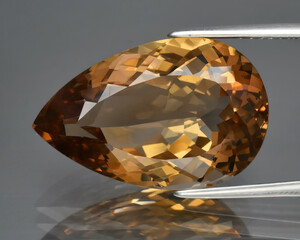 Natural gemstone orange imperial topaz on gray background