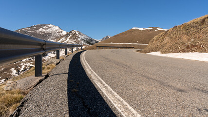 Perspective curve of the shadow on the containment barrier asphalt on the mountain road.