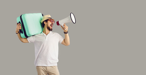 Start of vacation time, lockdown cancel, tour agency giveaway great discount announcement. Millennial caucasian man tourist traveler shouting in megaphone holding suitcase stand over studio copy space