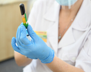  Plasma lifting - close-up of a doctor's hand in blue rubber gloves with a syringe. Plasmolifting...
