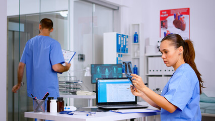 Clinician woman managing meeting schedule agenda appointment in hospital holding patient x-ray....