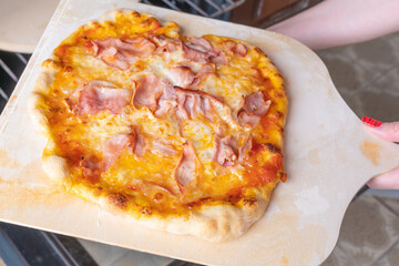 Homemade pizza on a wooden cutting board,close up,view from above.